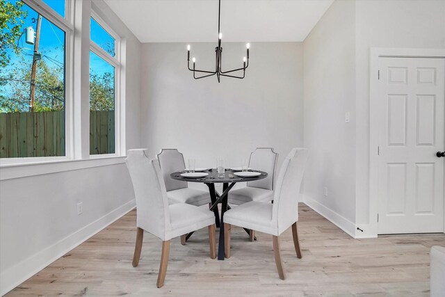 dining area with light hardwood / wood-style floors and a chandelier