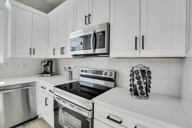 kitchen with appliances with stainless steel finishes, backsplash, and white cabinetry