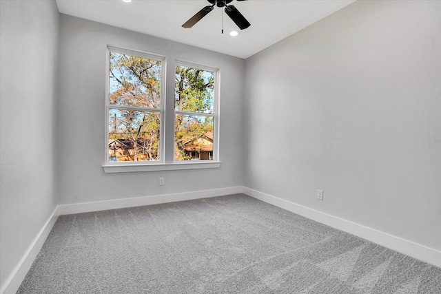 empty room featuring ceiling fan and carpet