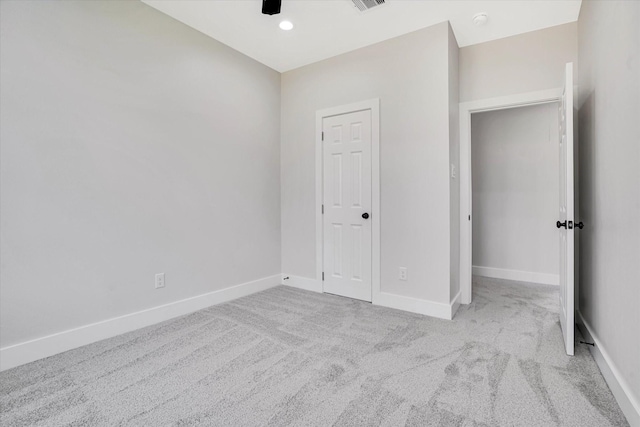 unfurnished bedroom with a closet and light colored carpet