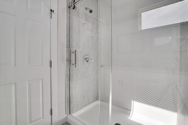 bathroom with a shower with door