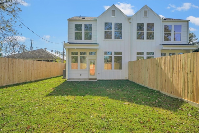 rear view of property featuring a yard