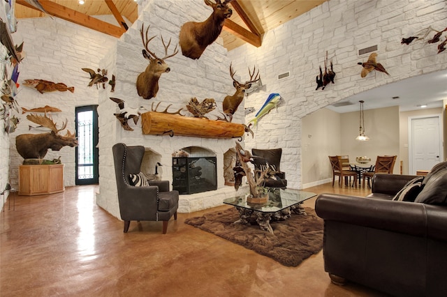 living room featuring beamed ceiling, concrete floors, high vaulted ceiling, and a stone fireplace