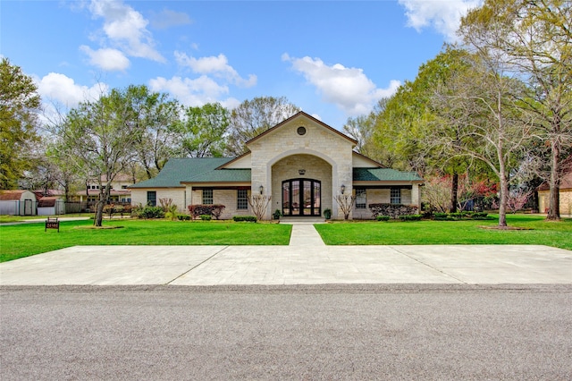 view of front facade with french doors and a front lawn