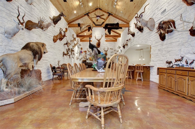 dining room with high vaulted ceiling and wood ceiling