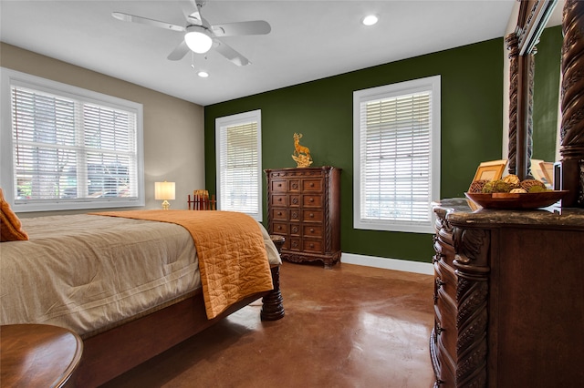 bedroom with multiple windows, ceiling fan, and concrete floors