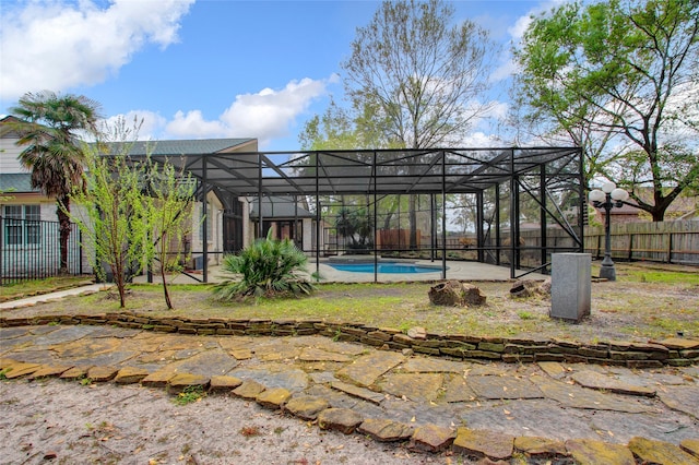 exterior space featuring a fenced in pool and glass enclosure