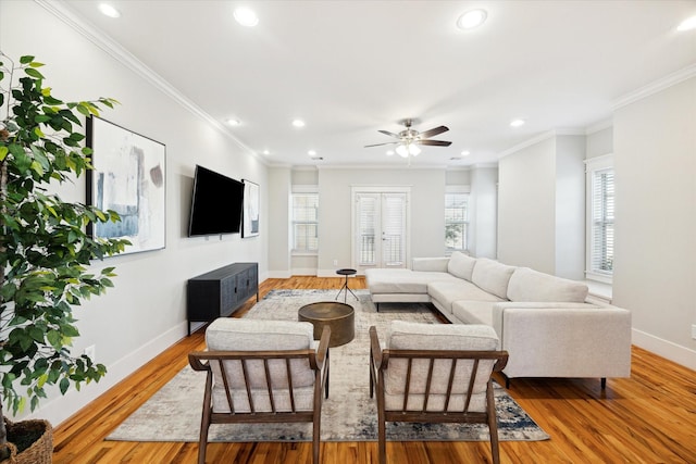 living room with ceiling fan, wood-type flooring, and ornamental molding