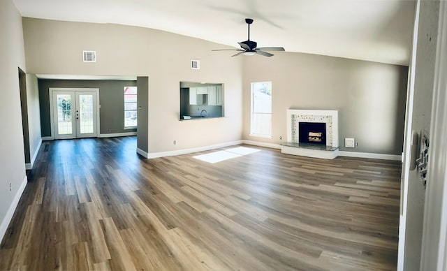 unfurnished living room with french doors, vaulted ceiling, ceiling fan, and dark wood-type flooring