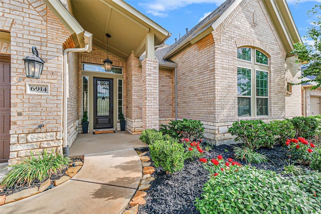 view of exterior entry with brick siding