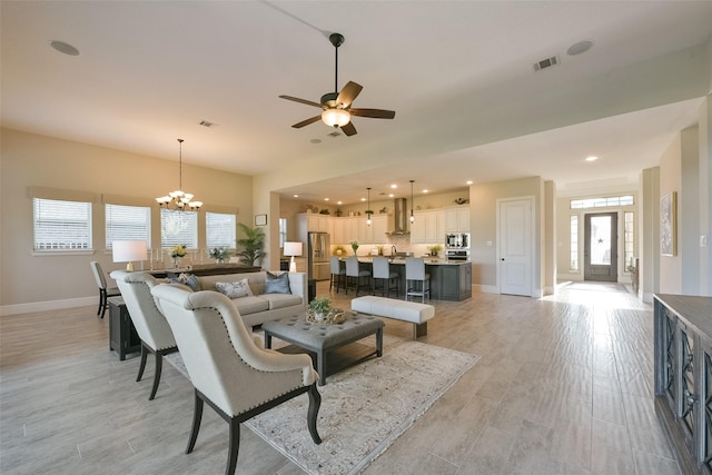 living room with light hardwood / wood-style flooring and ceiling fan with notable chandelier