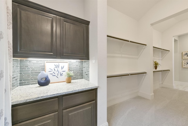 walk in closet with lofted ceiling