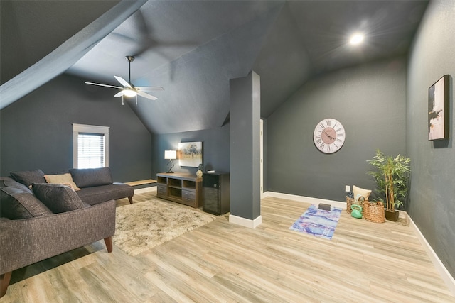 living room with ceiling fan, vaulted ceiling, and light wood-type flooring