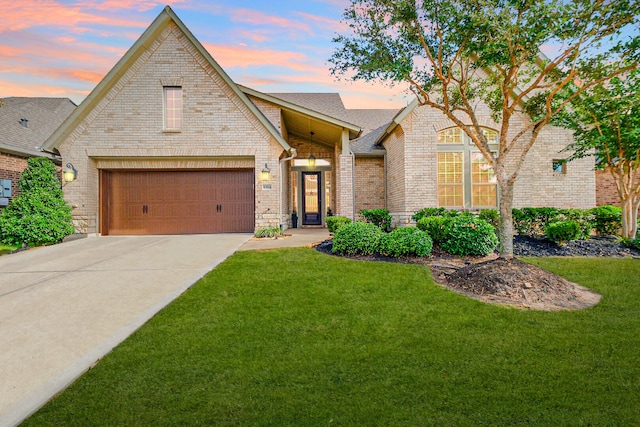 view of front facade featuring brick siding, a lawn, and an attached garage