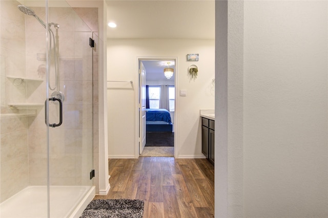 bathroom with vanity, hardwood / wood-style flooring, and a shower with door