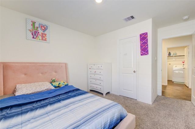 bedroom featuring carpet flooring and washer / dryer