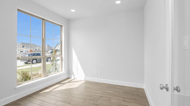 unfurnished room featuring recessed lighting, baseboards, and wood finished floors