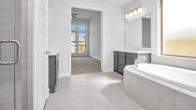 full bathroom with a bath, a shower stall, vanity, and baseboards