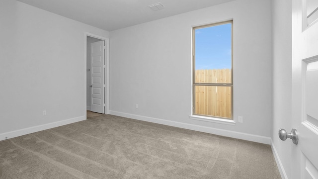 spare room with visible vents, baseboards, and carpet flooring