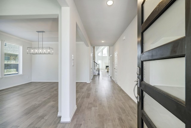 foyer entrance featuring light wood-type flooring and ornamental molding