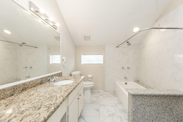 full bathroom with vanity, toilet, tiled shower / bath, and tile walls