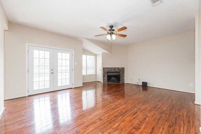 unfurnished living room with ceiling fan, wood-type flooring, a premium fireplace, and french doors