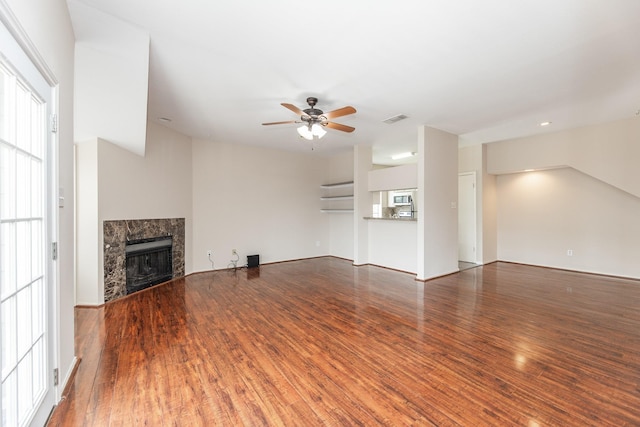 unfurnished living room with a fireplace, hardwood / wood-style flooring, and ceiling fan