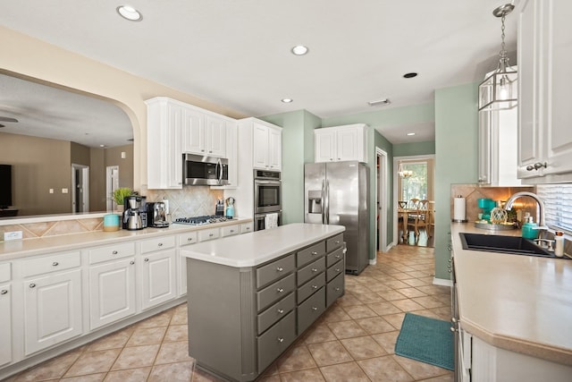 kitchen with white cabinetry, a kitchen island, pendant lighting, and appliances with stainless steel finishes