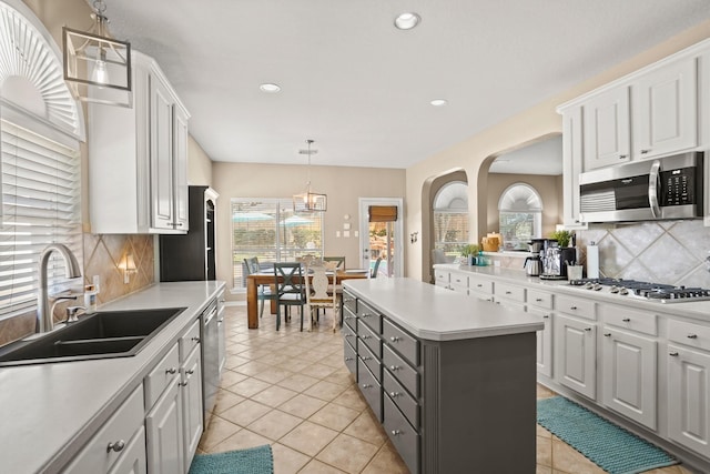 kitchen with white cabinets, backsplash, stainless steel appliances, and sink