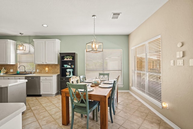 tiled dining room with sink and a notable chandelier