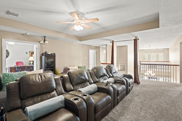 carpeted home theater with ceiling fan and a textured ceiling