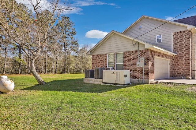 view of side of home featuring a yard, a garage, and cooling unit