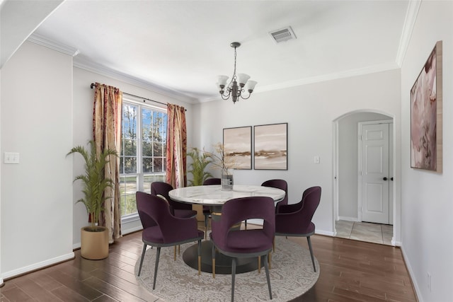 dining area with ornamental molding and an inviting chandelier