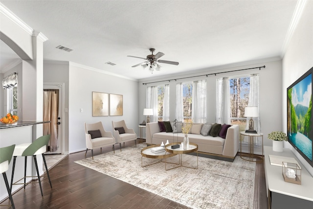 living room featuring dark hardwood / wood-style flooring, ceiling fan, and crown molding