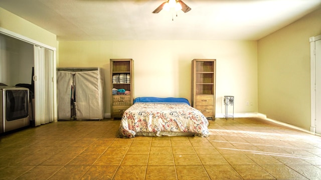 tiled bedroom featuring ceiling fan and washer / dryer