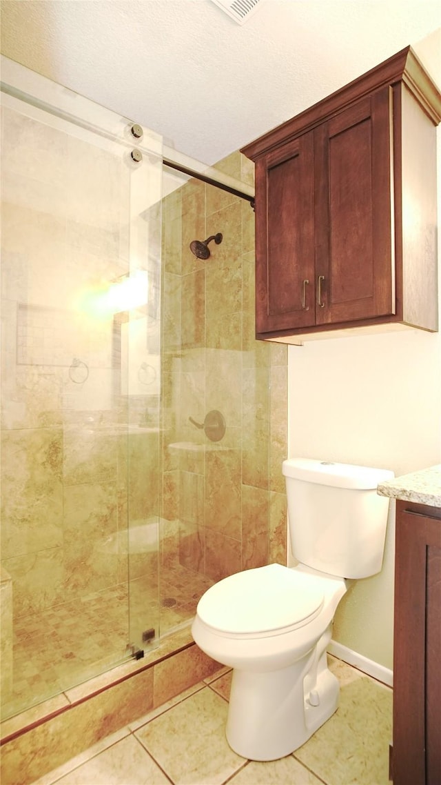 bathroom featuring tile patterned floors, vanity, toilet, and an enclosed shower