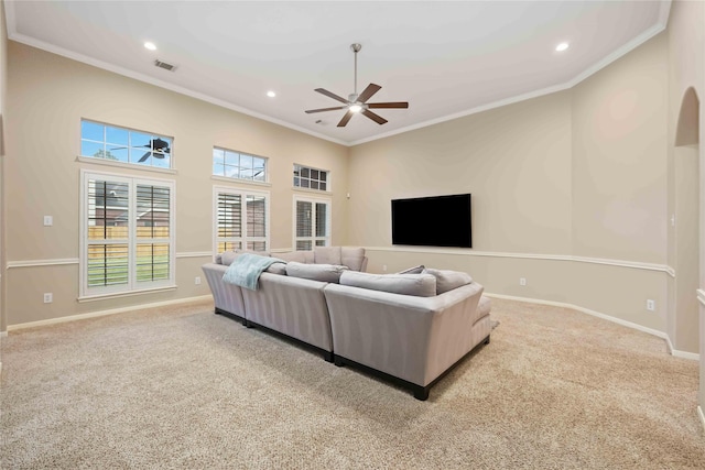 living room with ceiling fan, light colored carpet, and crown molding