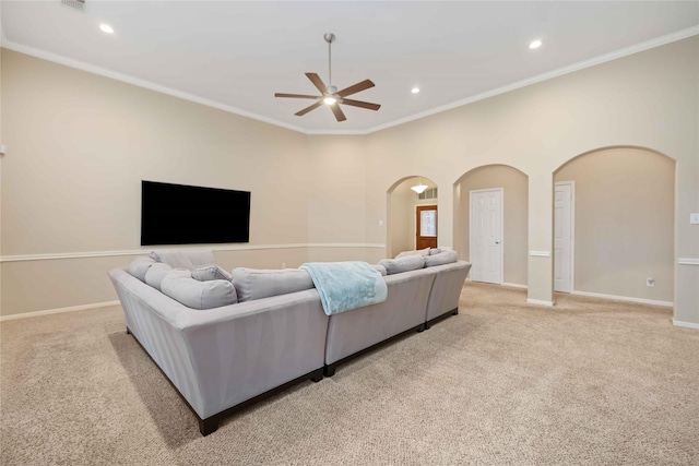 living room with crown molding, ceiling fan, and light colored carpet