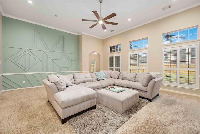 carpeted living room featuring ceiling fan and ornamental molding