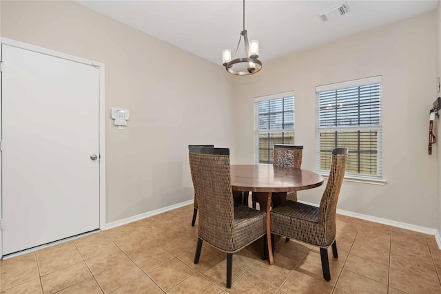 tiled dining area featuring an inviting chandelier