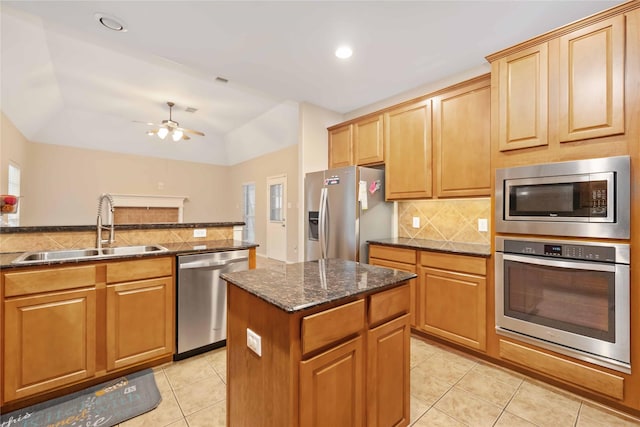 kitchen featuring light tile patterned flooring, sink, ceiling fan, a kitchen island, and stainless steel appliances