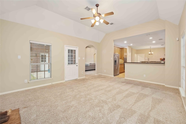 unfurnished living room featuring ceiling fan, light colored carpet, and lofted ceiling