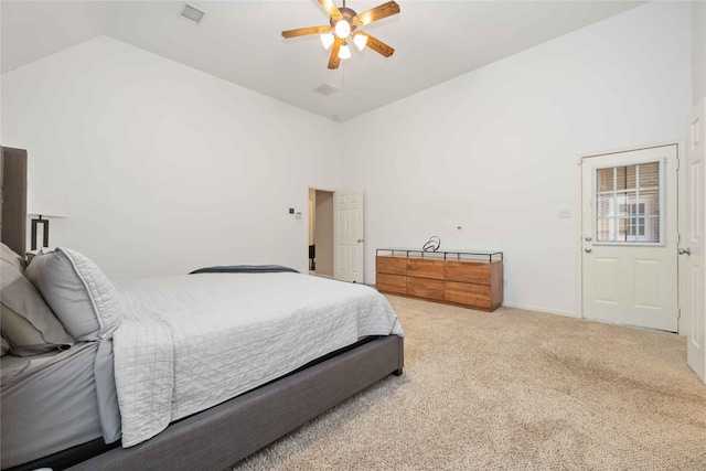 bedroom with ceiling fan, carpet floors, and a towering ceiling