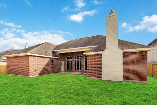 rear view of property featuring a patio area and a yard