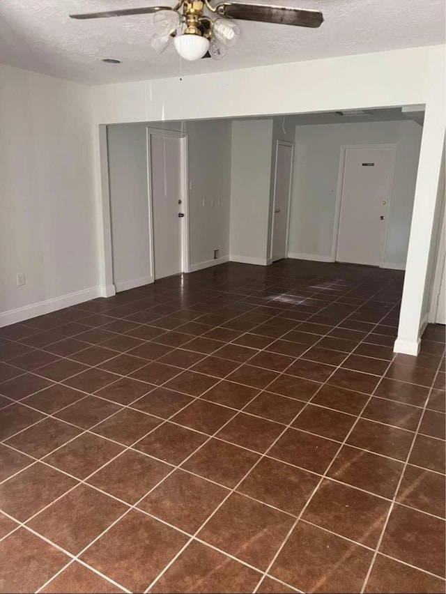 empty room with ceiling fan and a textured ceiling