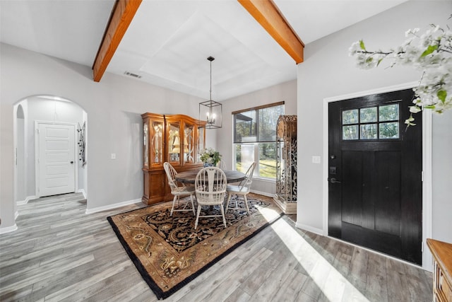 dining space featuring beam ceiling and light wood-type flooring