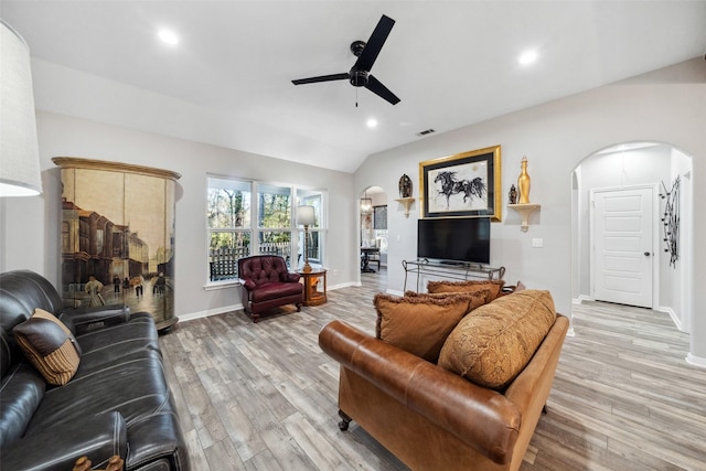 living room with light hardwood / wood-style floors, vaulted ceiling, and ceiling fan