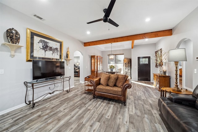 living room with ceiling fan, hardwood / wood-style floors, and beamed ceiling