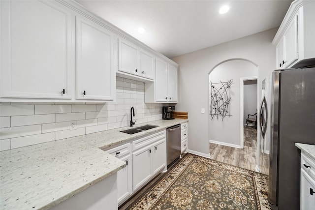 kitchen featuring light stone countertops, sink, white cabinets, and stainless steel appliances