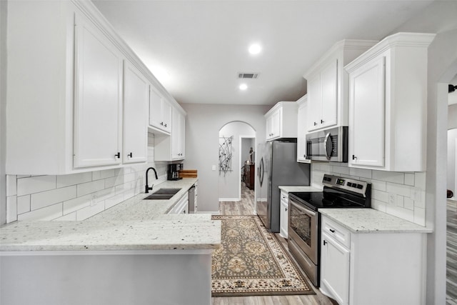 kitchen featuring white cabinets, decorative backsplash, sink, and stainless steel appliances